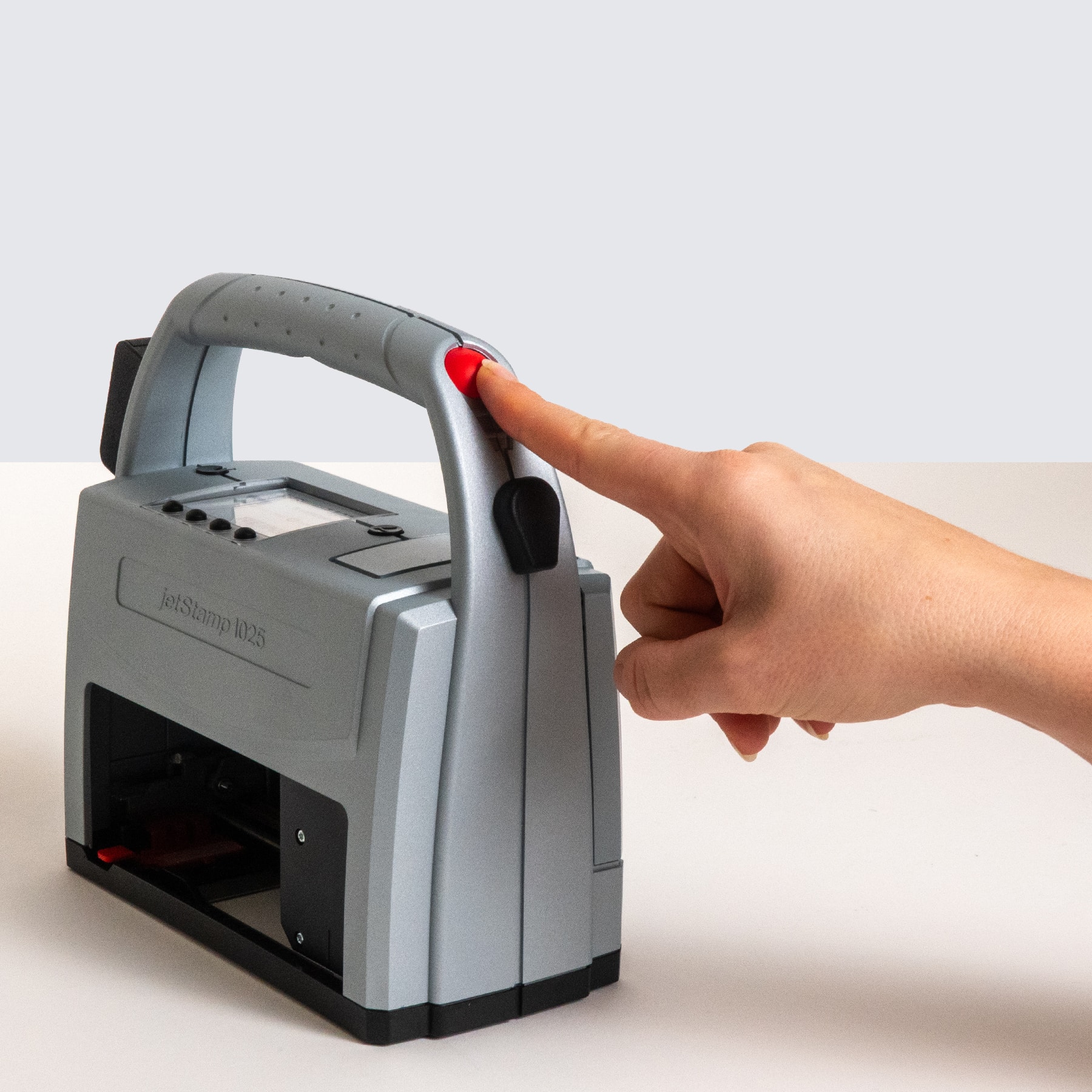 Betätigung der Auslösetaste am Griff des REINER jetStamp 1025 sense