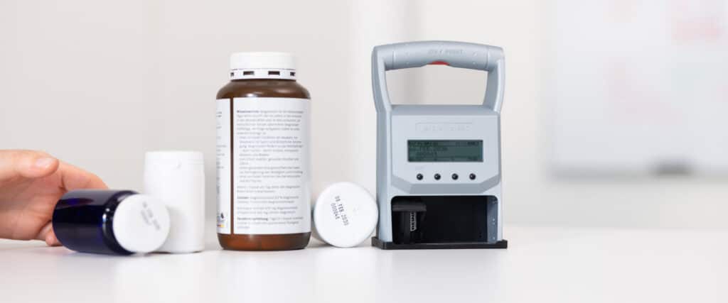 La REINER jetStamp graphic 970 marca directamente los envases de medicamentos con la fecha y el número de lote.