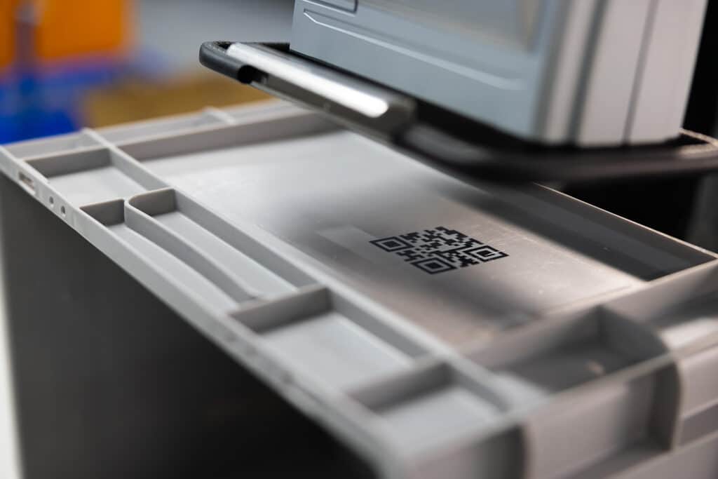 REINER jetStamp 1025 con plantilla guía ADHESIVO al crear una impresión de código QR en una superficie de plástico