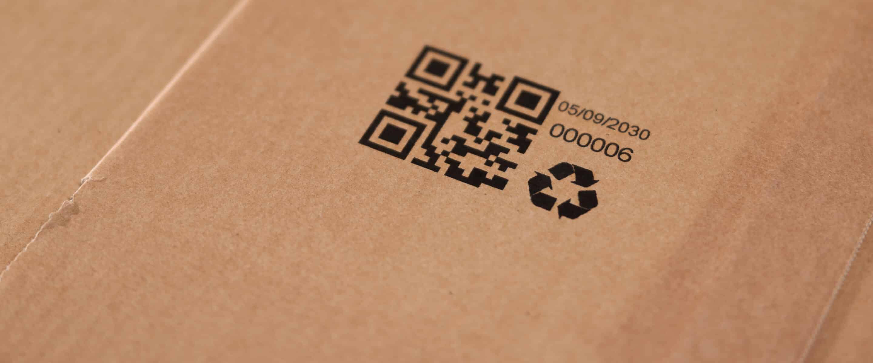 Karton mit QR-Code, Datum und Recycling-Symbol