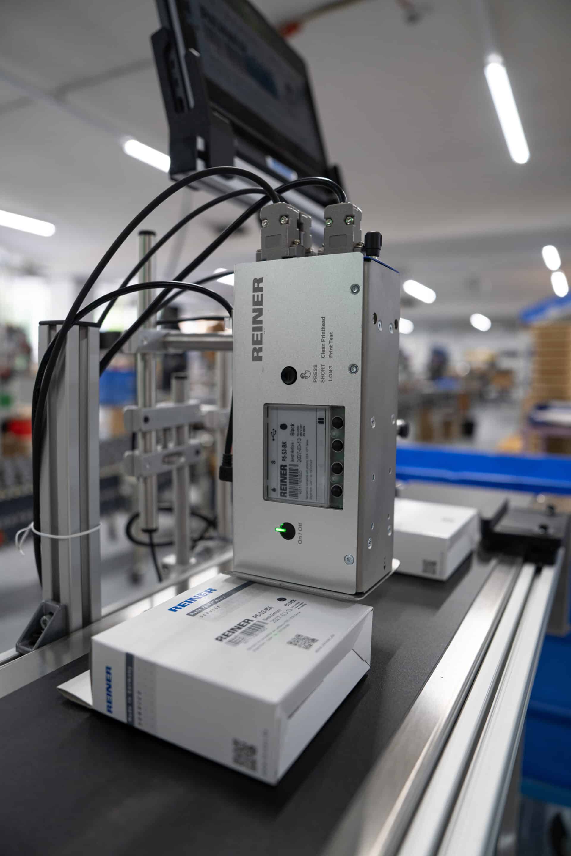 REINER jetAxis 100 bedruckt Verpackung auf Förderband