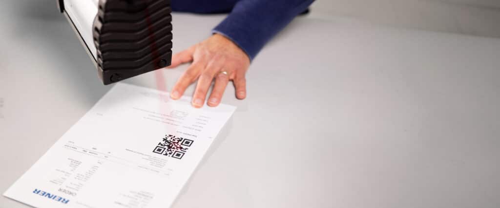 El REINER jetStamp 1025 sense escanea un código QR de un documento.