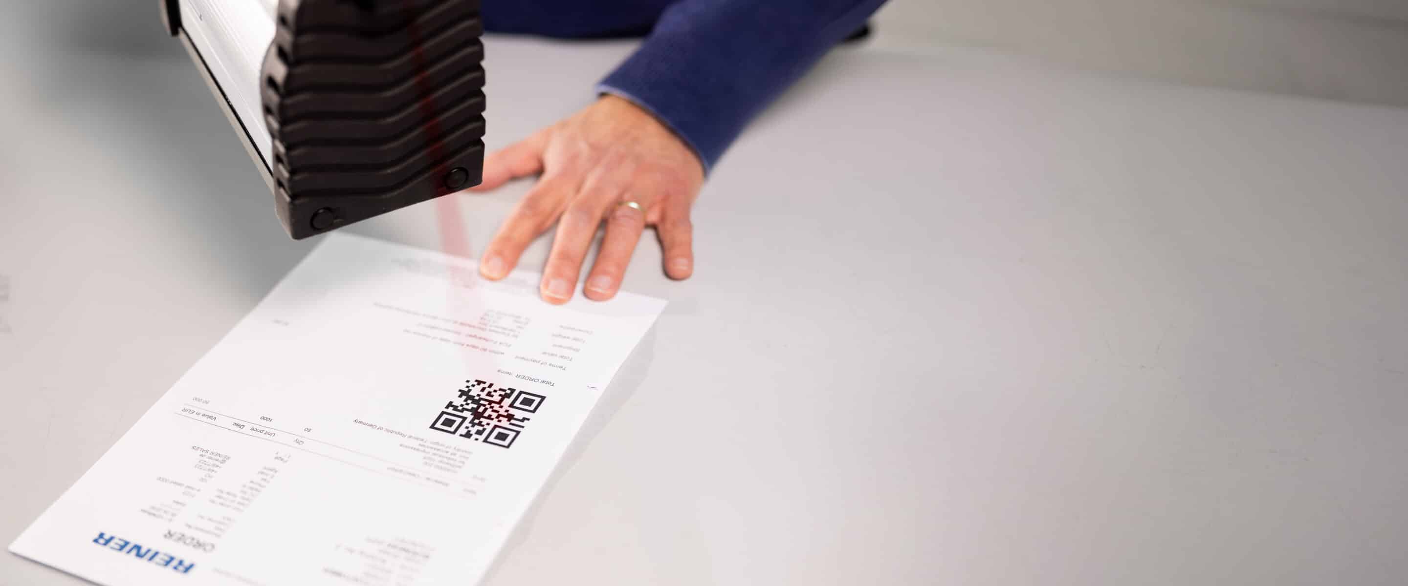 Le REINER jetStamp 1025 sense lit un code QR figurant sur un document.