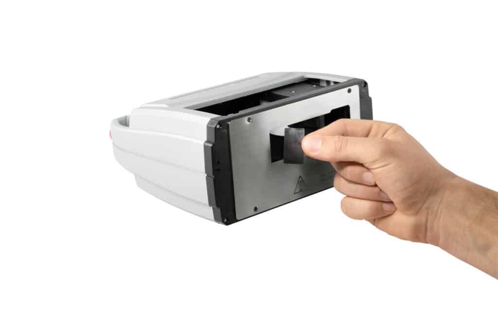 La mano inserta un recipiente colector de tinta en el jetStamp 1025