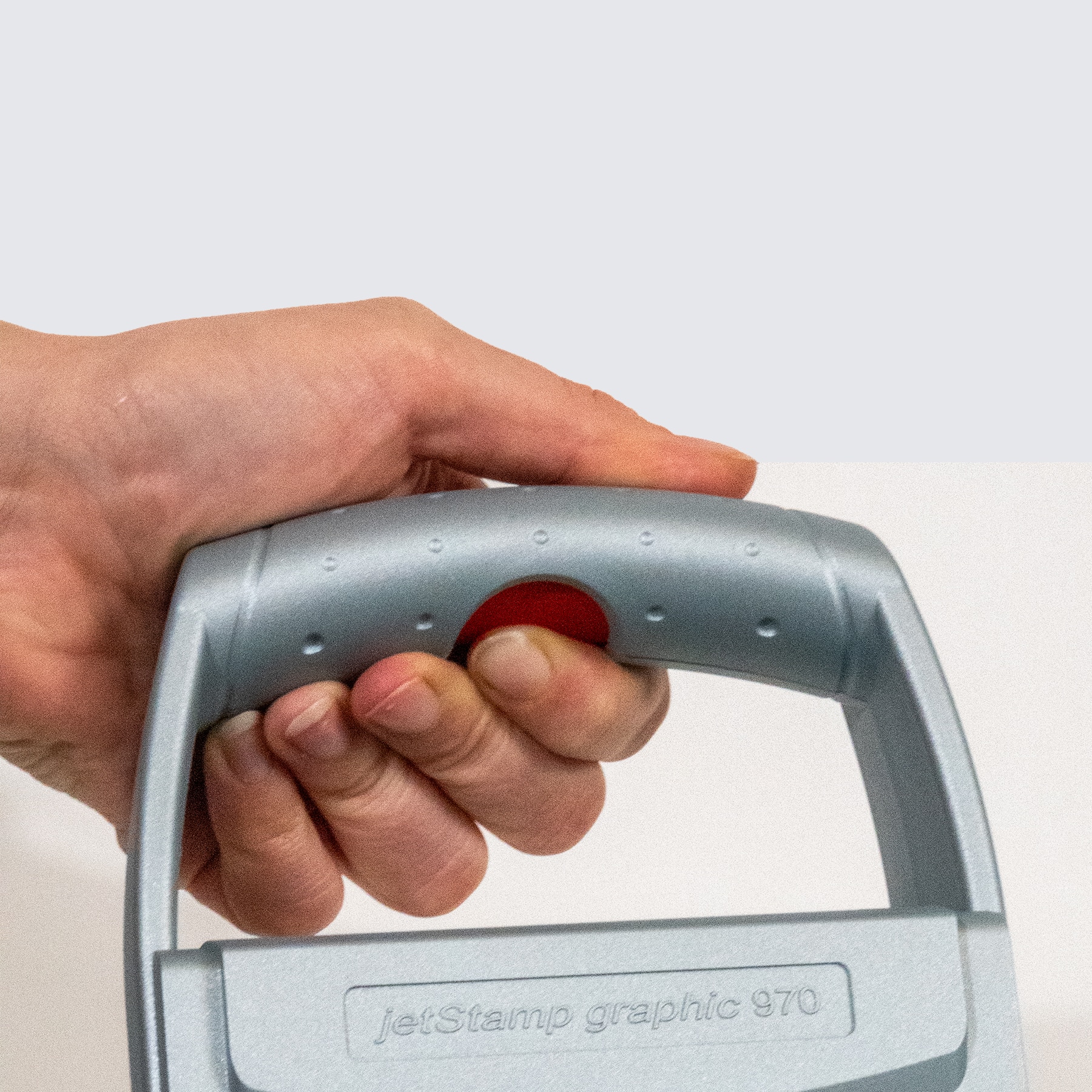 Hand presses the release button on the jetStamp graphic 970