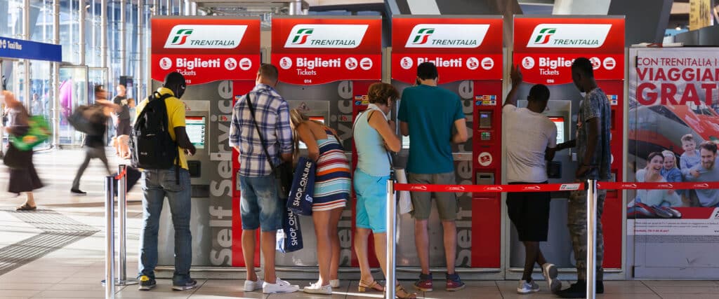 Fahrkartenautomaten im Bahnhof mit Reisenden